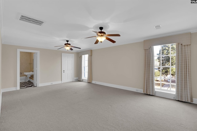 carpeted empty room with ceiling fan and crown molding