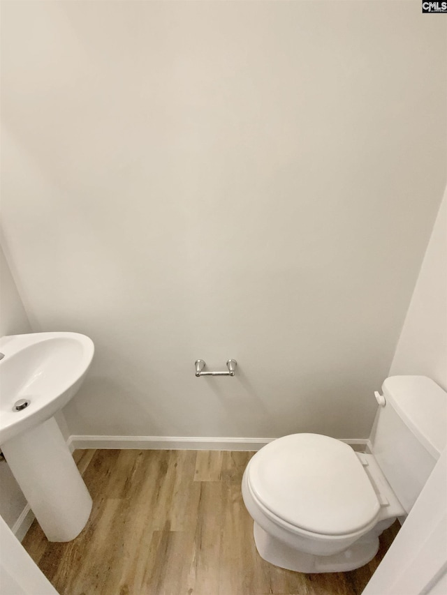 bathroom with hardwood / wood-style flooring and toilet