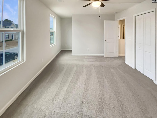 unfurnished bedroom featuring carpet flooring, a closet, and ceiling fan