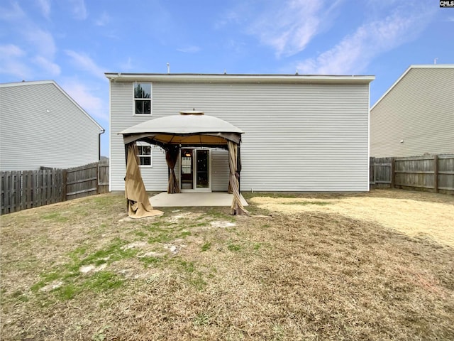 rear view of house with a patio area, a gazebo, and a yard