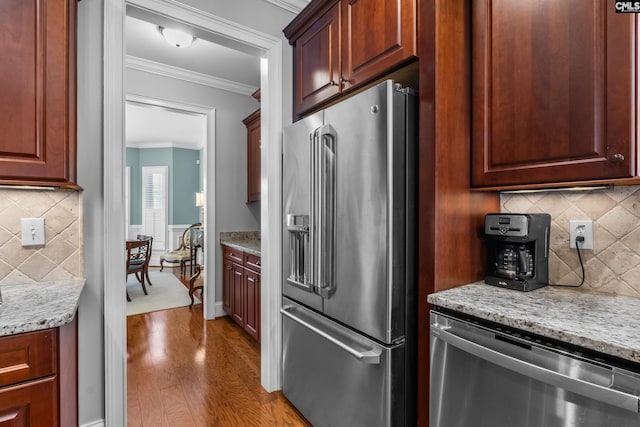 kitchen with light stone counters, crown molding, and stainless steel appliances