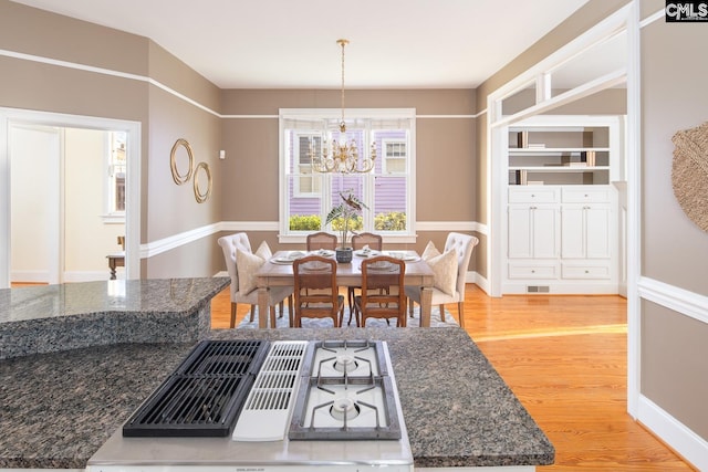 dining space featuring an inviting chandelier and light hardwood / wood-style flooring