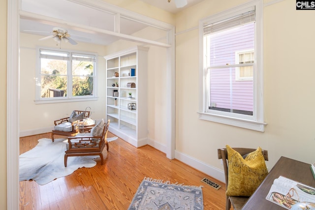 living area with ceiling fan and hardwood / wood-style flooring