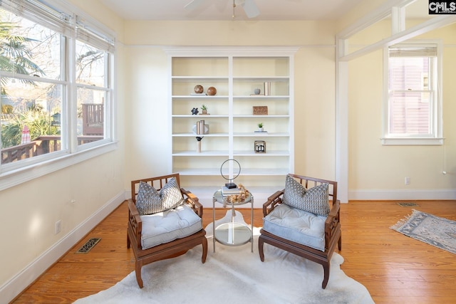 living area featuring built in features and light hardwood / wood-style flooring