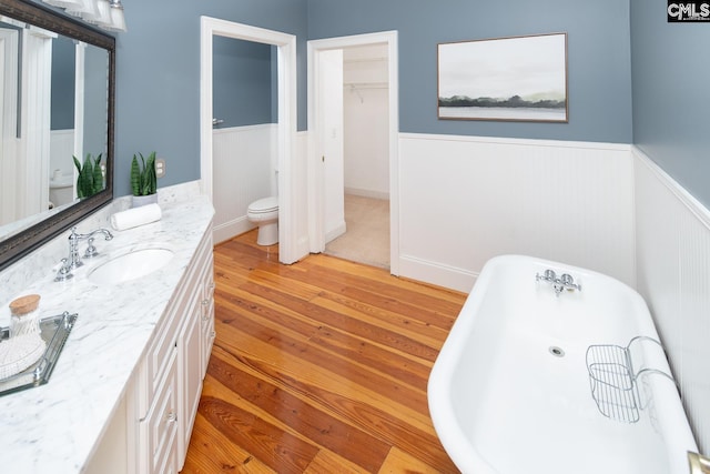 bathroom with vanity, a bathtub, wood-type flooring, and toilet