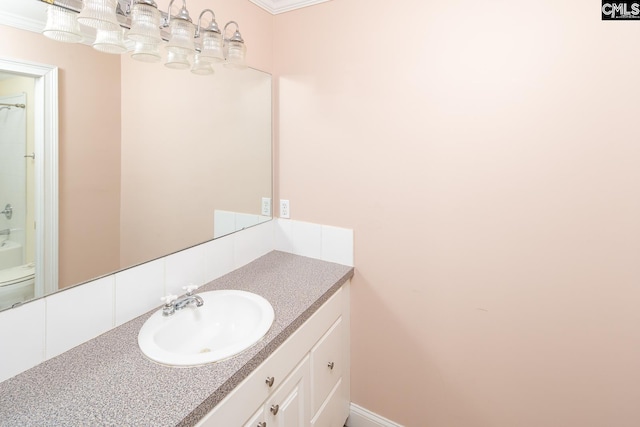 bathroom featuring toilet, vanity, and ornamental molding