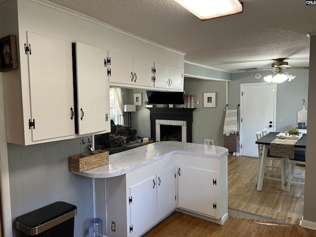 kitchen with white cabinets, kitchen peninsula, and hardwood / wood-style floors