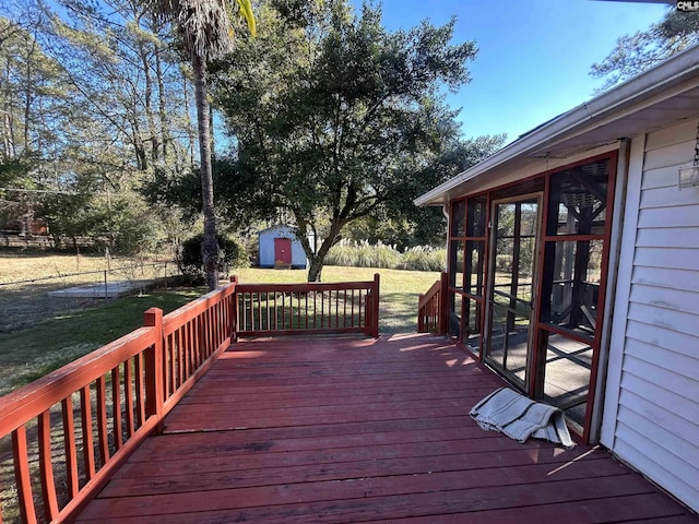 deck with a sunroom, a yard, a shed, and a trampoline