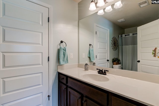 bathroom with toilet, vanity, and walk in shower