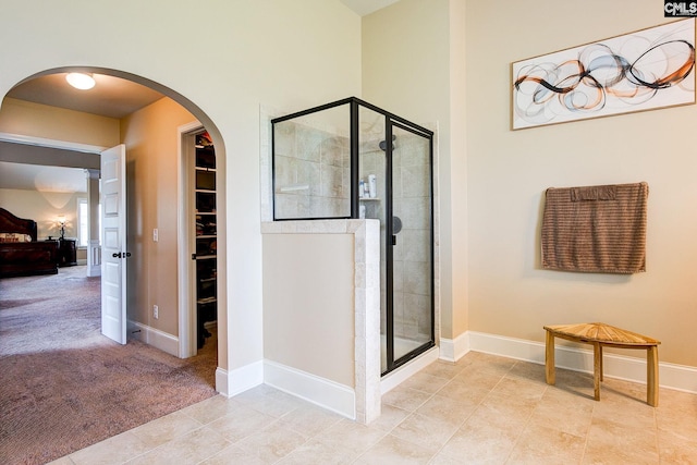bathroom featuring a shower with door and tile patterned floors