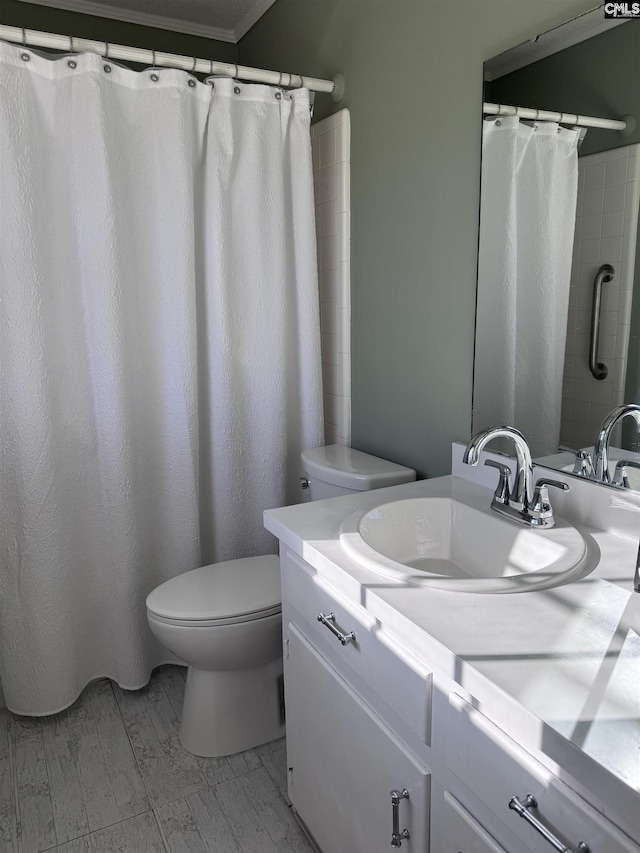 bathroom with toilet, vanity, ornamental molding, and a shower with shower curtain