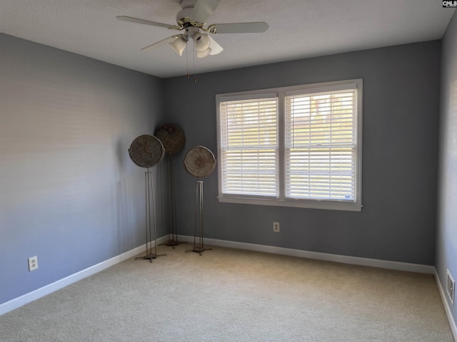 spare room featuring ceiling fan, a textured ceiling, and carpet floors