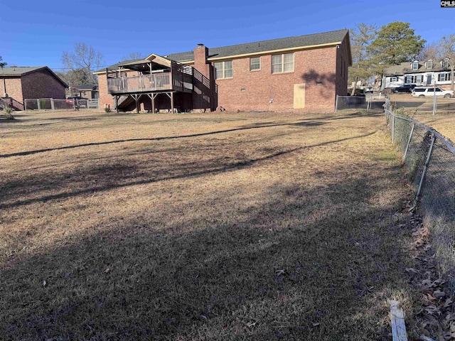 back of property featuring a lawn and a wooden deck