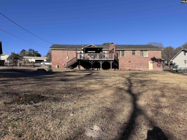 back of house featuring a deck and a lawn