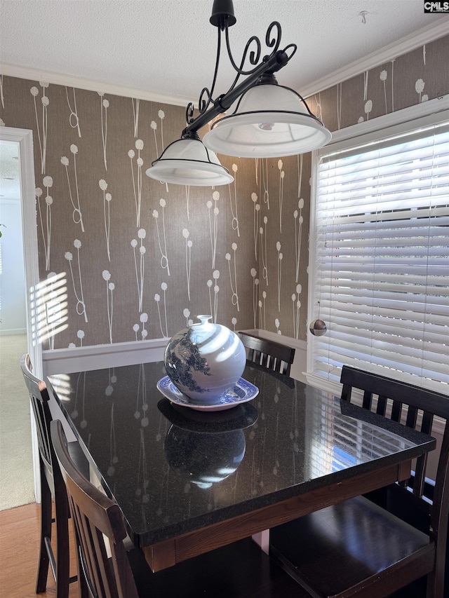 dining space featuring crown molding, a textured ceiling, and wood-type flooring