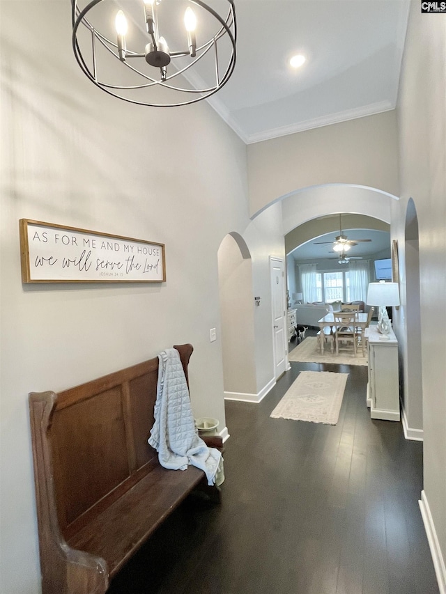 hallway with a chandelier, crown molding, and dark wood-type flooring