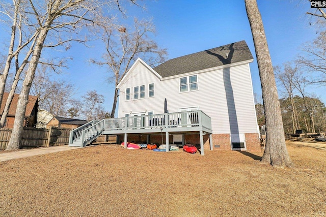 back of house with a wooden deck and a lawn