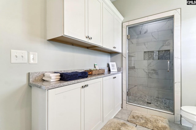 bathroom with toilet and a shower with shower door