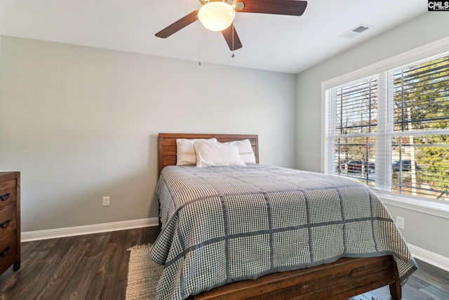 bedroom with multiple windows, ceiling fan, and dark hardwood / wood-style flooring