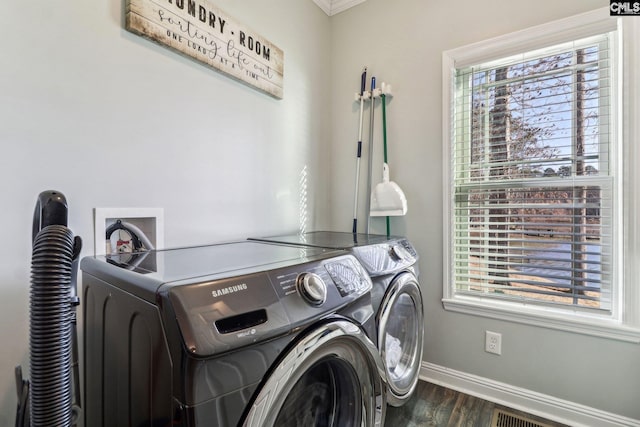 washroom featuring ornamental molding, dark wood-type flooring, and separate washer and dryer