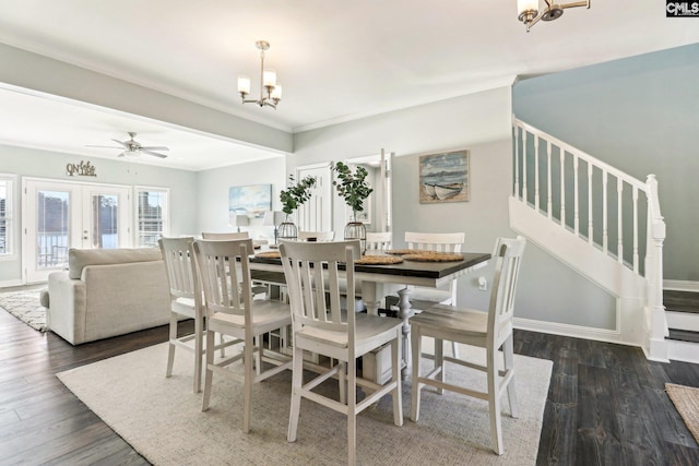 dining room with ceiling fan with notable chandelier, dark wood-type flooring, ornamental molding, and french doors