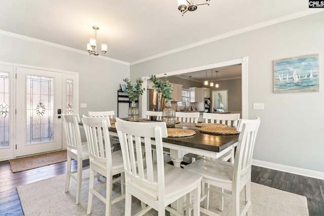 dining room featuring a notable chandelier, ornamental molding, and dark wood-type flooring