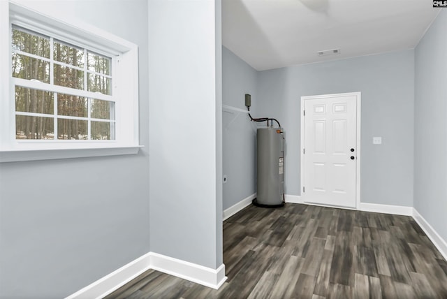 foyer entrance with dark wood-type flooring and electric water heater