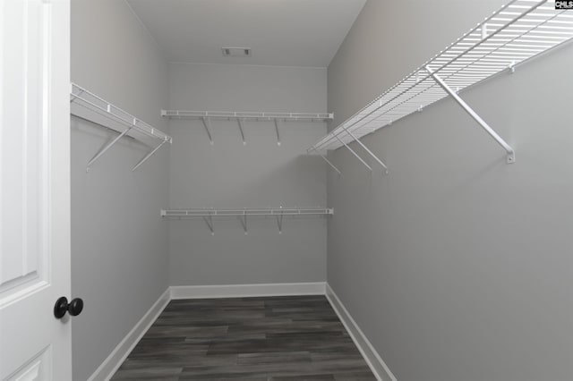 walk in closet with dark hardwood / wood-style floors