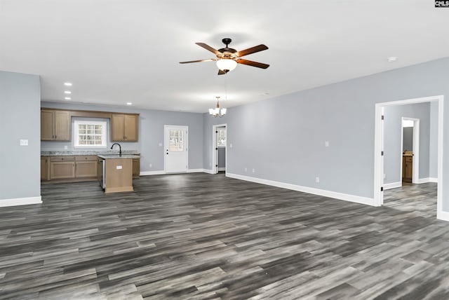 unfurnished living room featuring sink, ceiling fan with notable chandelier, and dark hardwood / wood-style floors