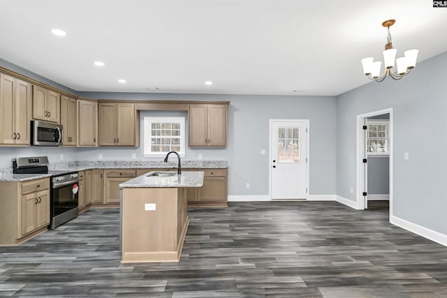 kitchen featuring a kitchen island with sink, light stone counters, stainless steel appliances, and a healthy amount of sunlight