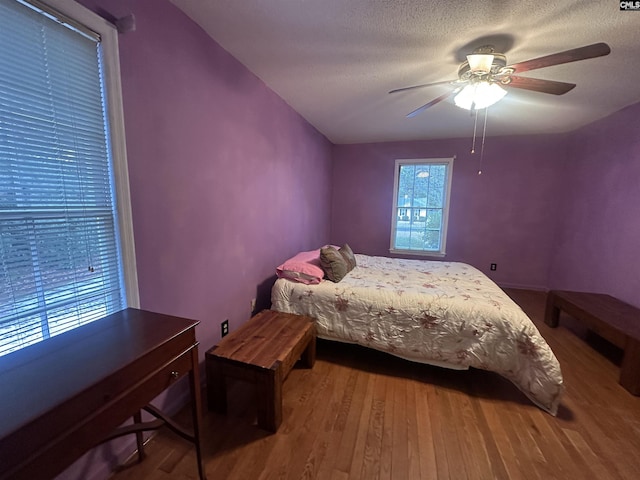 bedroom featuring hardwood / wood-style flooring, ceiling fan, and a textured ceiling