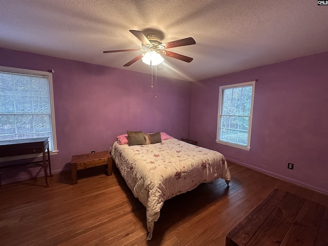 bedroom with hardwood / wood-style flooring, ceiling fan, and a textured ceiling