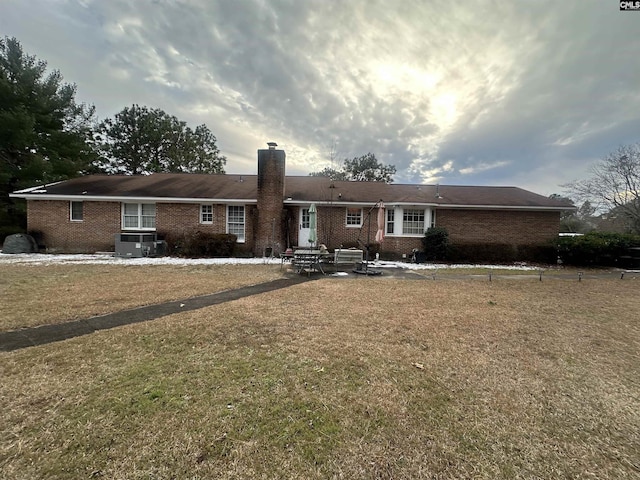 single story home with cooling unit and a front lawn