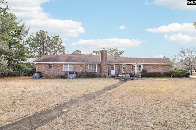 back of property featuring central AC unit, a lawn, and a patio area