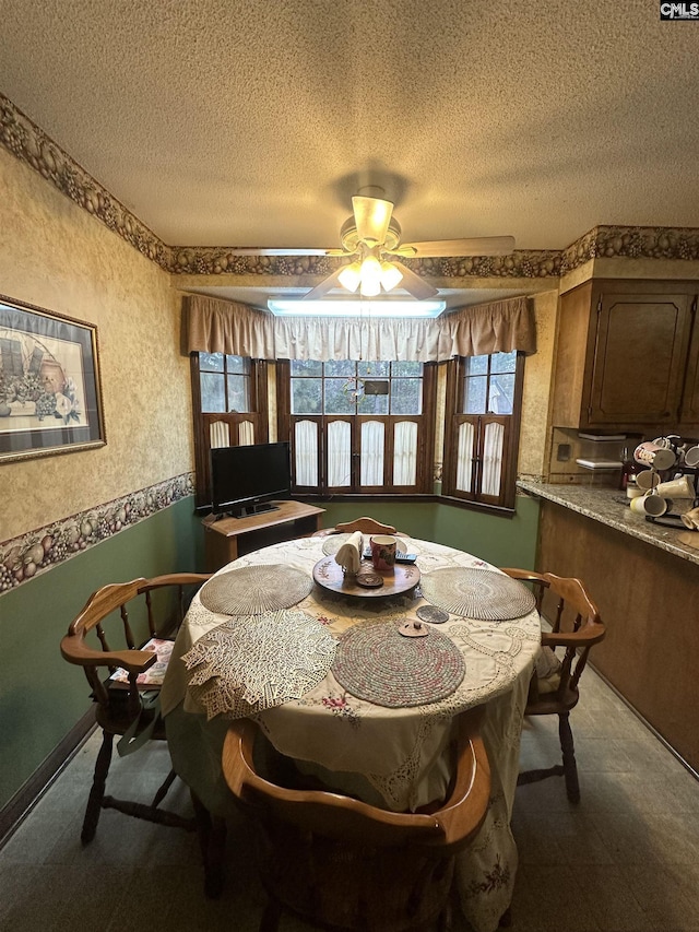 dining space featuring ceiling fan, plenty of natural light, and a textured ceiling