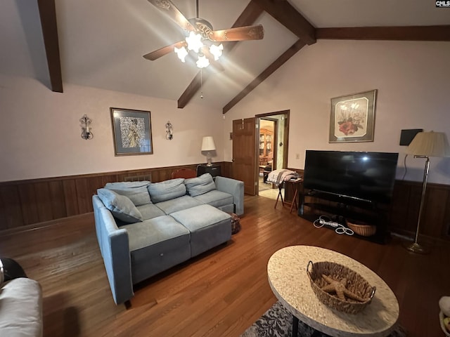 living room featuring hardwood / wood-style flooring, wood walls, ceiling fan, and vaulted ceiling with beams