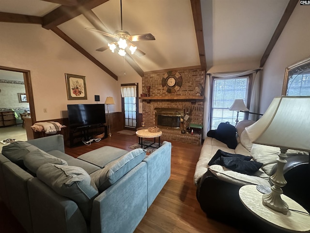 living room featuring ceiling fan, a fireplace, lofted ceiling with beams, and hardwood / wood-style floors