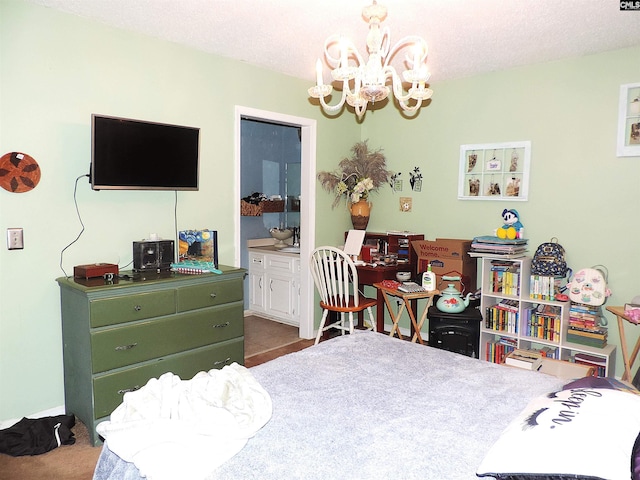 carpeted bedroom with a chandelier, ensuite bathroom, and a textured ceiling