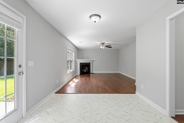 unfurnished living room with ceiling fan and light hardwood / wood-style flooring