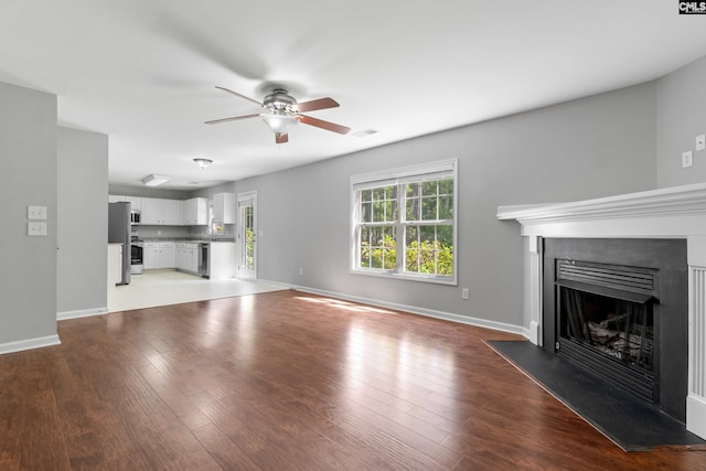 unfurnished living room with light wood-type flooring and ceiling fan