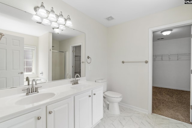 bathroom featuring a shower with door, vanity, and toilet