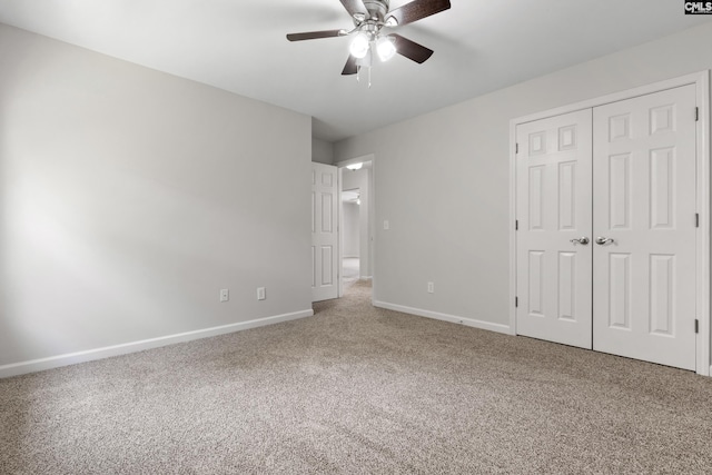 unfurnished bedroom with carpet, ceiling fan, and a closet