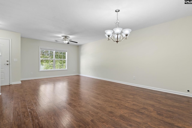 empty room with dark hardwood / wood-style floors and ceiling fan with notable chandelier