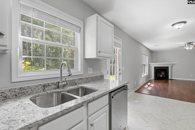 kitchen with white cabinetry, light stone countertops, sink, and stainless steel dishwasher