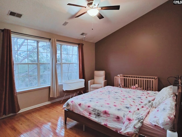 bedroom with lofted ceiling, wood-type flooring, and ceiling fan