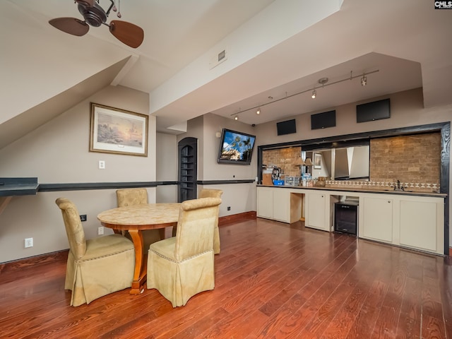 dining room featuring dark wood-type flooring, lofted ceiling, sink, ceiling fan, and beverage cooler