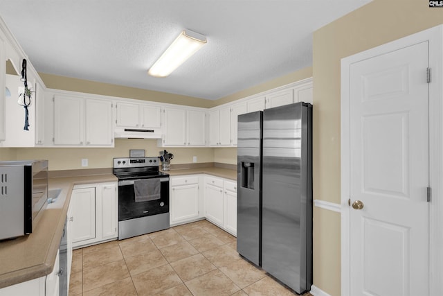 kitchen featuring light tile patterned flooring, stainless steel appliances, a textured ceiling, and white cabinets