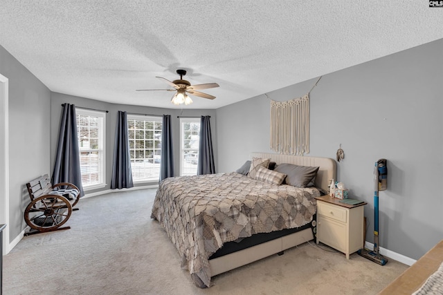 carpeted bedroom featuring ceiling fan and a textured ceiling