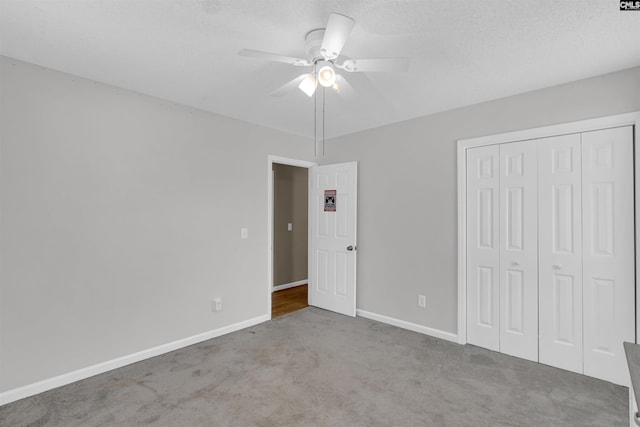 unfurnished bedroom with ceiling fan, light colored carpet, and a closet