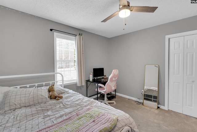 bedroom with a textured ceiling, carpet floors, a closet, and ceiling fan